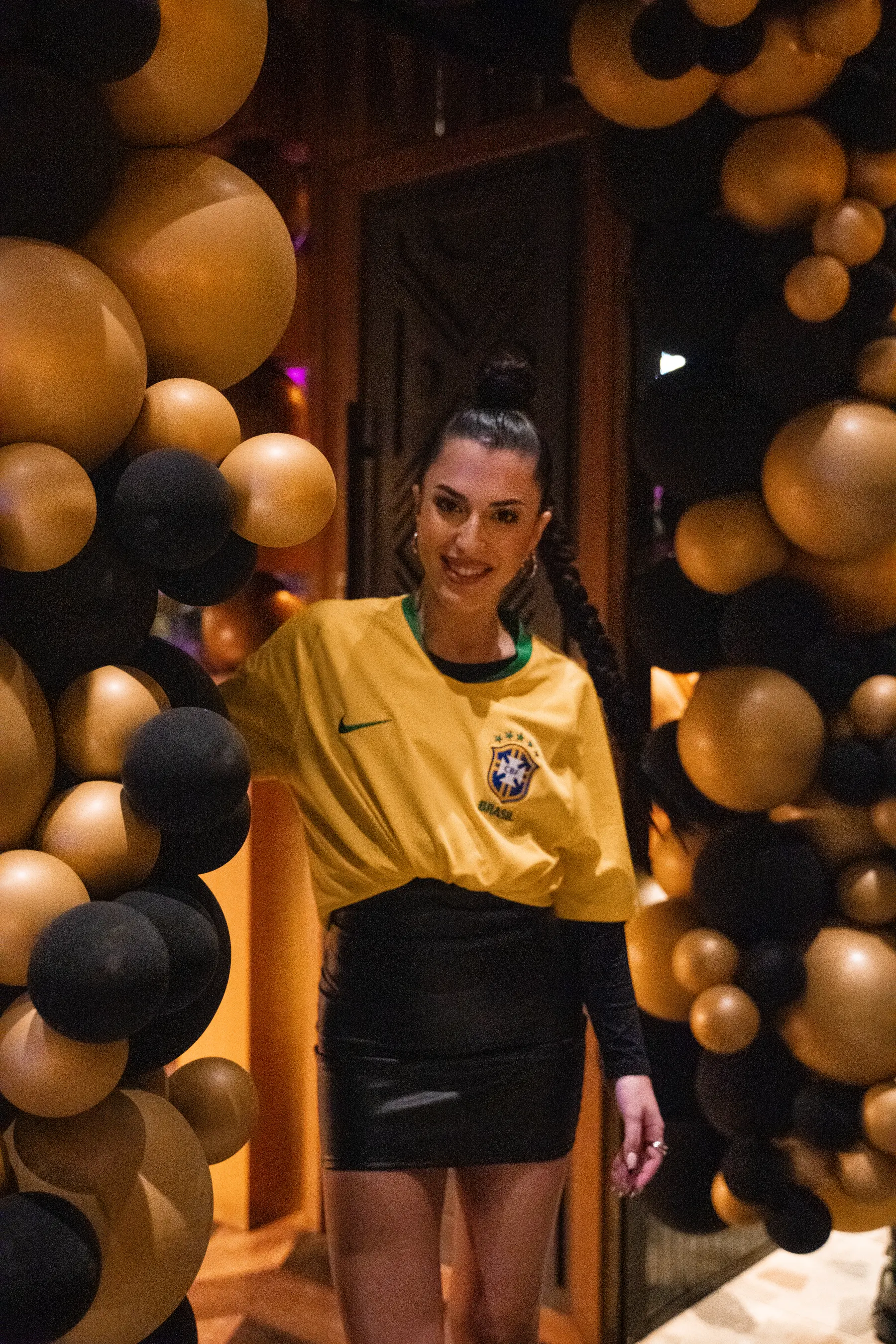 Un'invitata tra palloncini neri e oro a un compleanno da Iguazu Athens