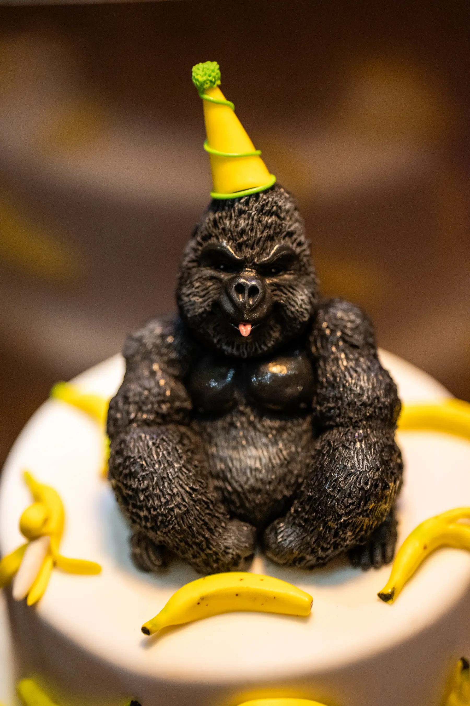 Torta di compleanno con sopra un gorilla con il cappellino da festa e le banane, da Iguazu Athens