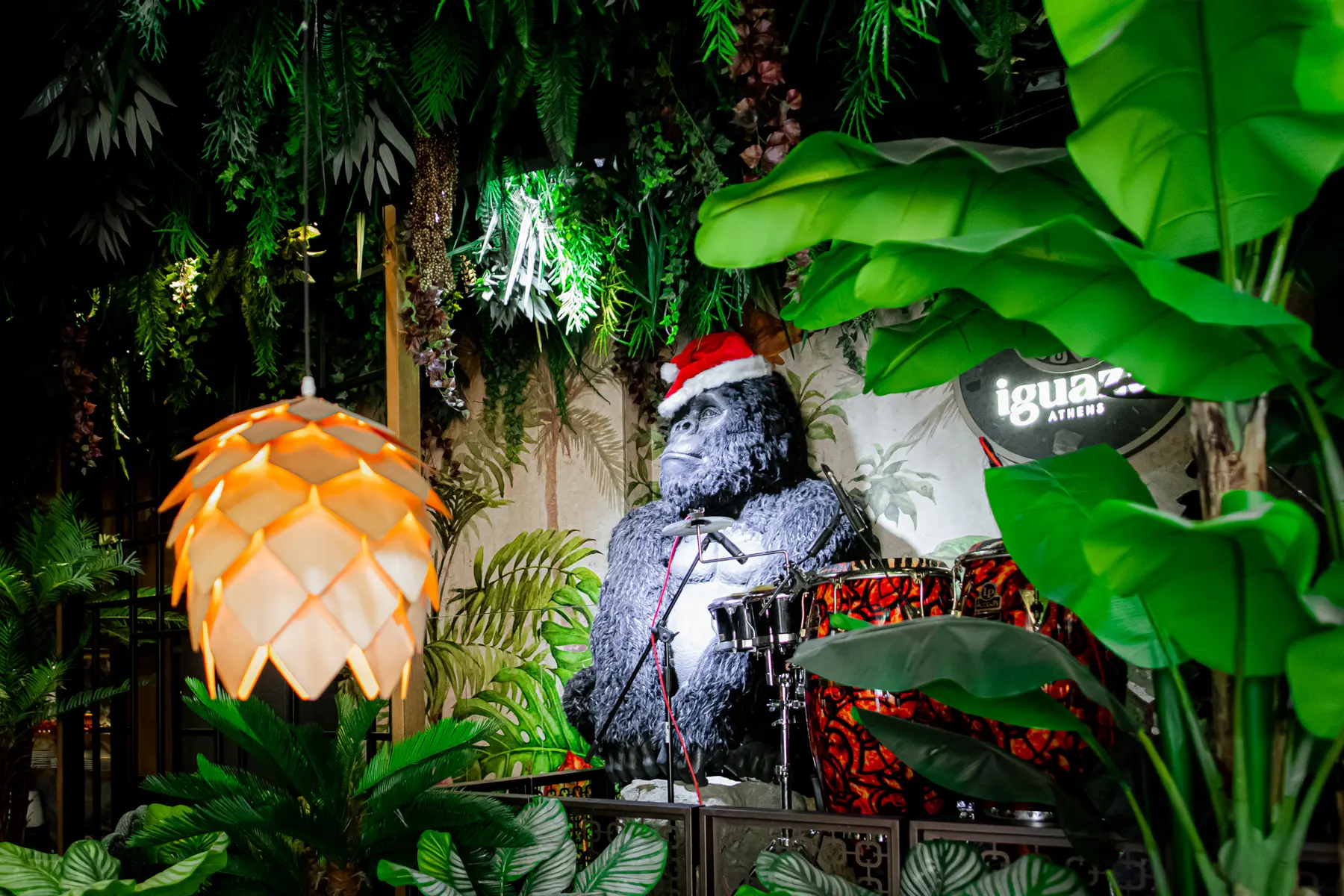Il gorilla con il cappello da Babbo Natale tra le foglie di banano da Iguazu Athens