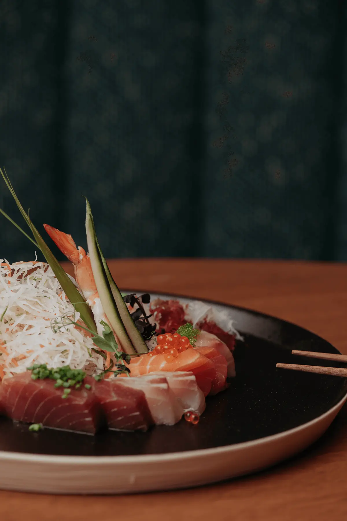 Sashimi impiattato con guarnizione croccante e bacchette