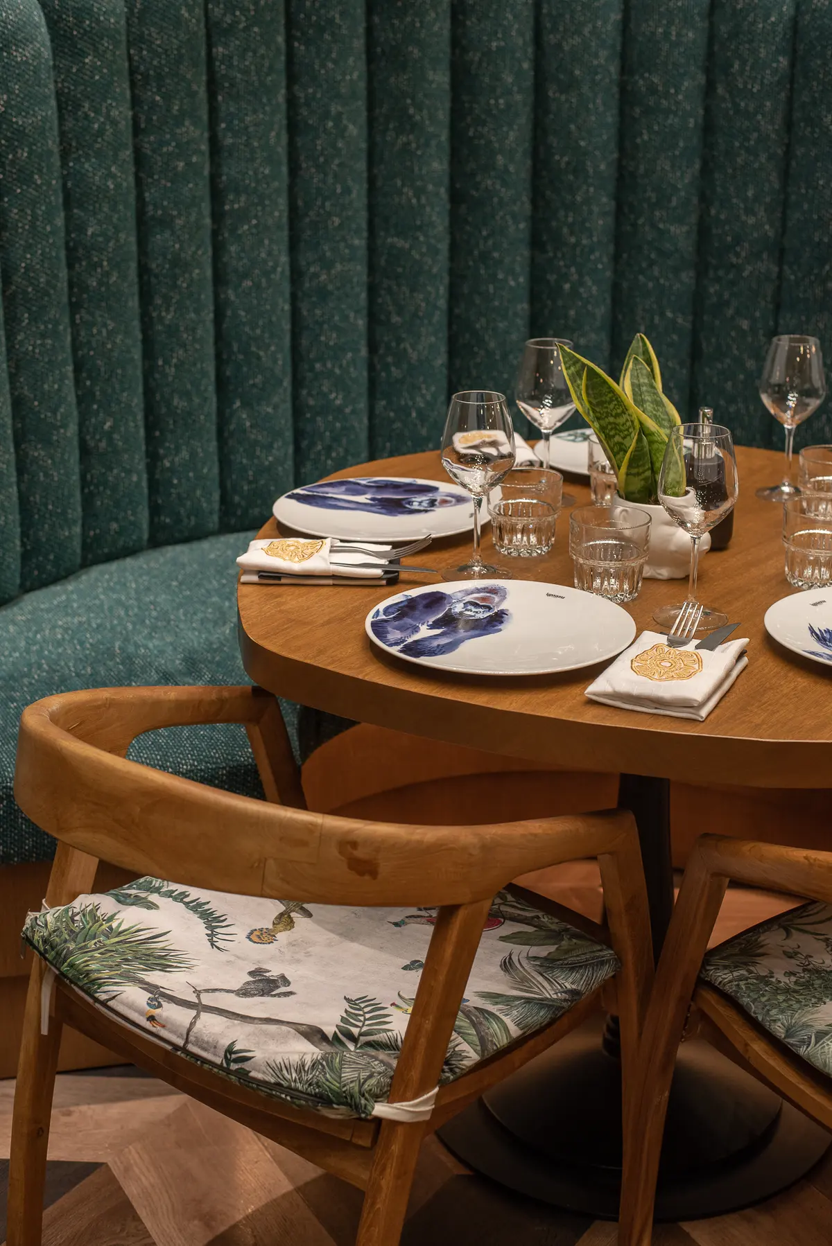Un tavolo apparecchiato con piatti decorati e bicchieri da Iguazu Athens